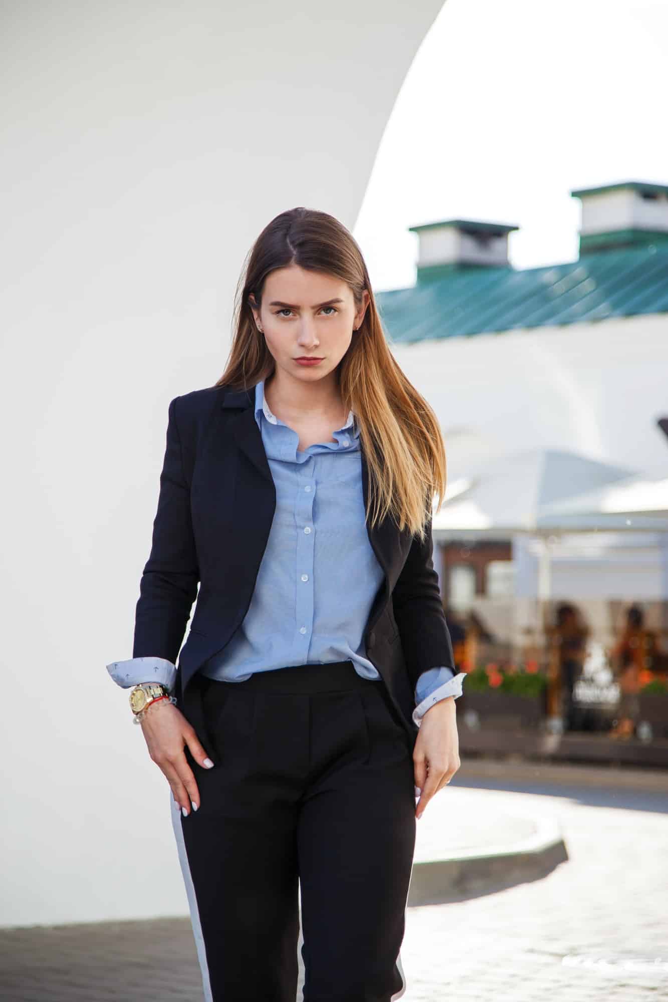 Fashionable women's look with black jacket and blue blouse.